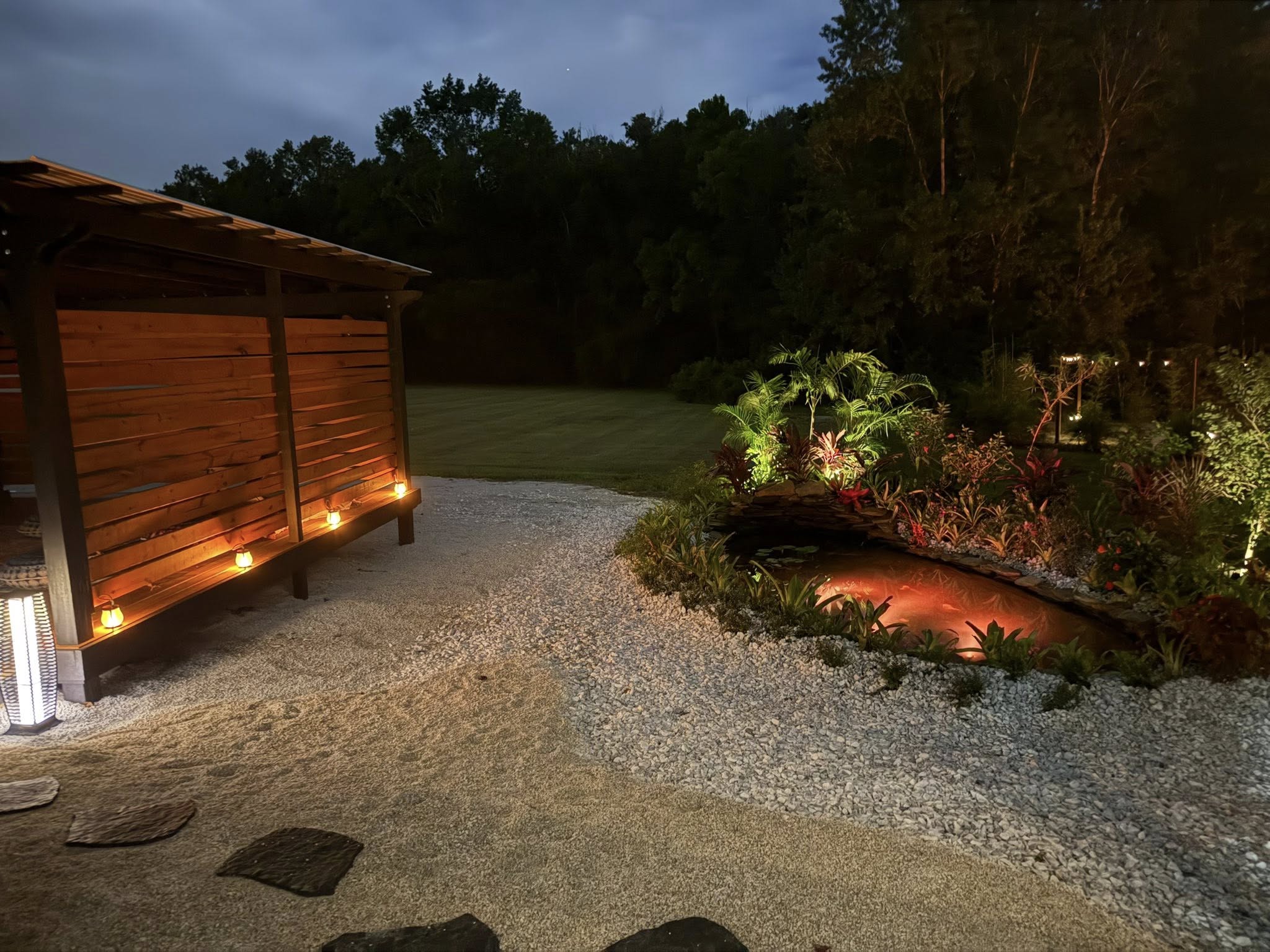 This looks like a peaceful backyard oasis featuring professionally designed landscape lighting.